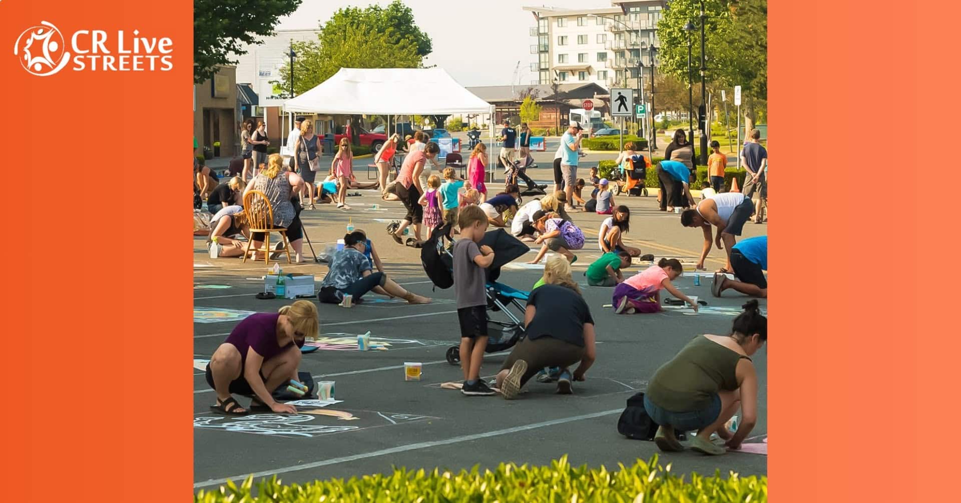 People of all ages draw colorful chalk art on a closed city street during the River City Streets Fest. Trees, buildings, and a white tent line the background. The CR Live Streets logo appears in the top left corner.