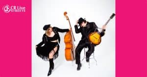 Two musicians pose against a white background; a woman with a double bass channels swing vibes in a black fringe dress and hat, while a man in a black suit and hat sits on a stool holding a guitar. Pink borders and the "CR Live Streets" logo are present.