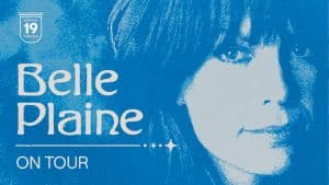 Blue-toned poster with a close-up of Belle Plaine’s face on the right. Text on the left reads “Belle Plaine ON TOUR.” A small shield-shaped logo above says “Highway 19 Concerts.”.
